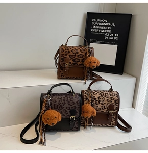 Detailed display of leopard print bags with teddy pendants and tassels on white stands