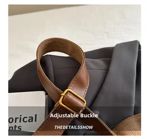 Detail of adjustable shoulder strap buckle on a brown leather vintage bucket bag