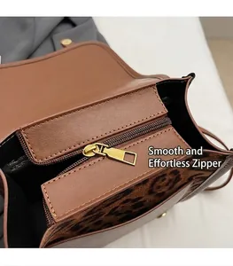 Close-up of smooth gold metal zipper and internal pocket on leopard print handbag