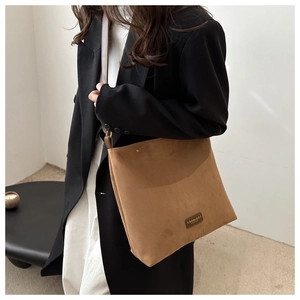 Close-up of a brown suede shoulder bag with fine texture and branded fashion tag