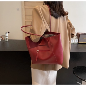 Deep red faux leather tote bag showing back zipper pocket and high-capacity minimalist design