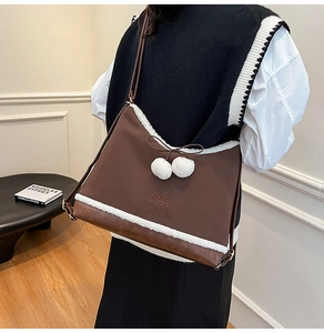 Detail of brown PU leather crossbody bag with white plush trim and bow embroidery