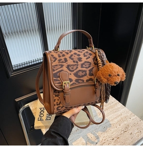 Detail of leopard print backpack with teddy charm and brown faux leather patchwork