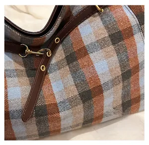 Gros plan du tissu à carreaux du cabas avec texture premium et détails de la bandoulière