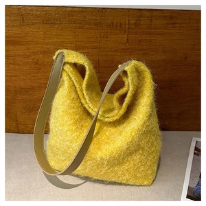 Dettaglio ravvicinato della borsa a spalla in ecopelliccia gialla con cuciture in pelle