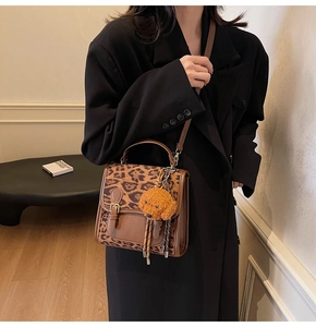 Brown leather crossbody bag with leopard print panel and cute plush dog charm detail