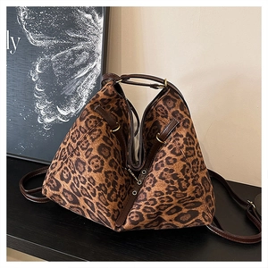Détail du sac cabas léopard avec cordon en cuir marron et boucles métalliques dorées