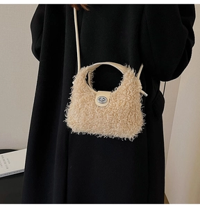 Detail of beige faux fur crossbody bag with silver metal swivel lock and leather handle