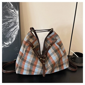 Détail de la texture à carreaux et des lanières en cuir marron du grand sac cabas