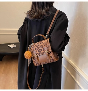 Detail view of large capacity vintage leopard print handbag with plush charm