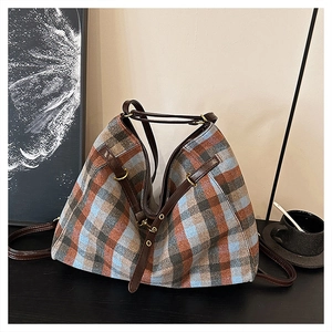 Vue détaillée du grand sac cabas à carreaux avec lanières en cuir brun et anneaux d'or