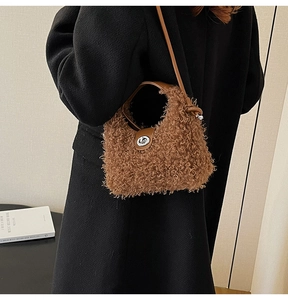 Detail of a brown plush dumpling bag with a silver buckle and leather strap