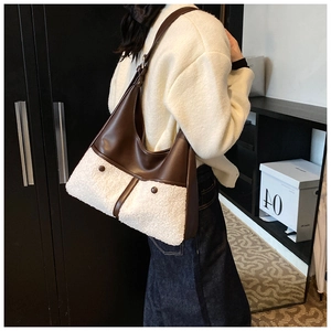 Close-up of winter Hobo bag featuring brown leather stitching and white faux fur detail