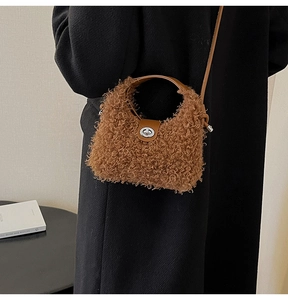 Detail of plush brown teddy shearling handbag with leather handle and silver swivel lock