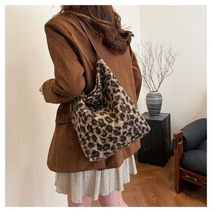 Dettaglio di una borsa a spalla in peluche con stampa leopardata indossata da modella