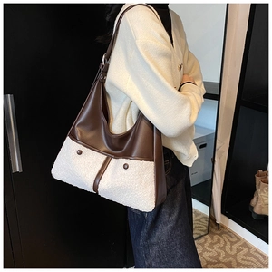 Detail of trendy tote bag featuring brown leather and white faux shearling texture