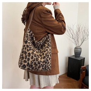 Dettaglio della borsa tote leopardata con tracolla in pelle marrone su modella