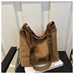 Detail of vintage brown suede hobo tote bag featuring a leather strap and bronze buckle