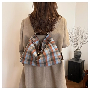 Détail d'un sac à bandoulière vintage à carreaux avec lanières en cuir sur modèle