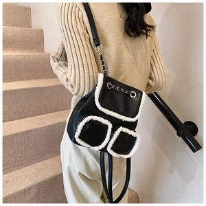 Detail of a black leather backpack with white faux shearling trim on stairs