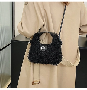 Detail of black plush crossbody bag featuring a leather flap and silver twist lock