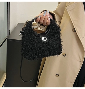 Detail of black curly faux fur handbag featuring a round silver lock and knot handle