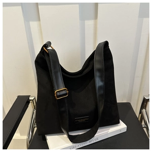 Detail of matte black hobo bag featuring wide strap and golden metal buckle