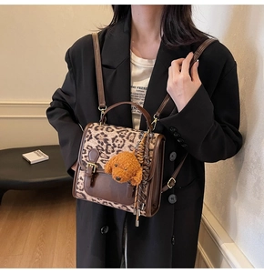 Detail of large brown leopard print backpack with a cute teddy dog plush keychain