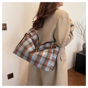 Détail du grand sac cabas à carreaux avec bordures en cuir marron et boucle métallique