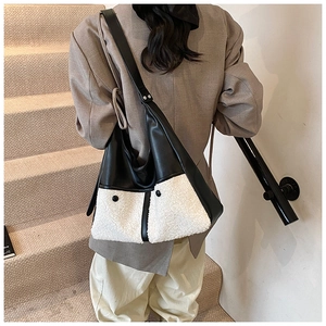 Detail of winter crossbody bag featuring black PU leather and white faux shearling patchwork