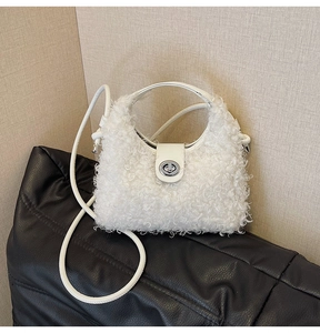 Detailed view of white faux shearling bag featuring silver metal twist lock and leather strap