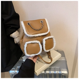 Detailed close-up of brown faux leather backpack with white sherpa trim and chain decor