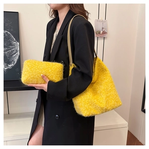 Dettaglio della borsa tote e pochette in peluche giallo acceso con tracolla su modella
