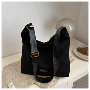 Detail view of the black oversized bucket bag with gold buckle and fashion label detail
