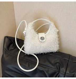 Detailed shot of white faux shearling handbag with silver metal lock and leather strap