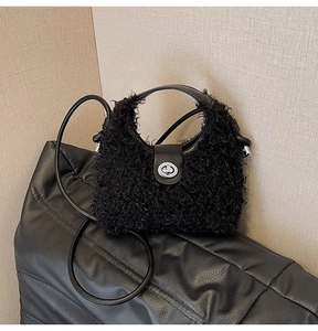 Close-up of fluffy black faux shearling handbag with silver metal twist lock detail