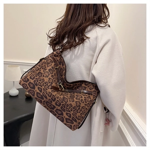 Détail du grand sac cabas léopard avec lanières en cuir marron et crochets dorés