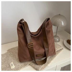 Close-up of retro brown frosted tote bag with wide leather strap and gold buckle detail