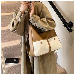 Detail view of large tote bag featuring brown leather and white faux shearling patchwork