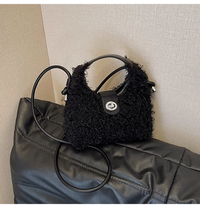 Detail of plush black faux fur handbag featuring silver oval metal twist lock and leather strap