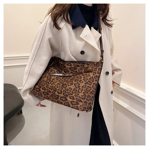Détail du grand sac cabas léopard avec lanières en cuir marron et boucles métalliques