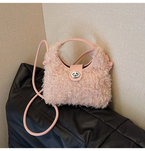 Detail view of pink plush crossbody bag with leather handle and silver metal turn-lock