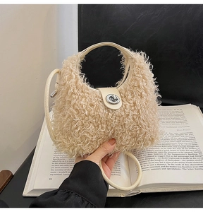 Close-up of beige plush faux shearling handbag with silver twist-lock and slim strap