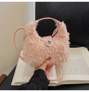 Detail of pink faux shearling plush bag with silver twist lock and leather handle