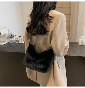 Model trägt eine schwarze Kunstfell-Schultertasche in einem eleganten Café Rückansicht