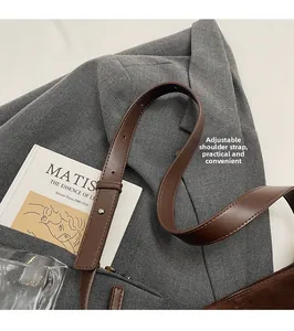 Detail of adjustable leather strap and brown frosted suede texture on a vintage handbag