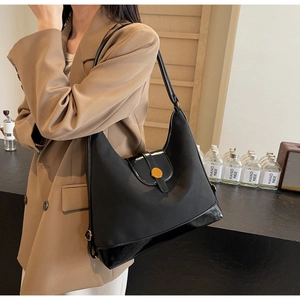 Close-up of black tote bag showing premium nylon texture and shiny patent leather detail