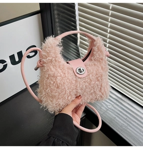 Detail of light pink plush handbag with soft faux fur texture and silver twist lock