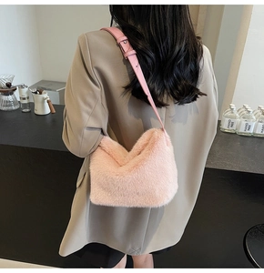 Detailansicht der rosa Kunstfell-Schultertasche mit Lederriemen in Lifestyle-Szene