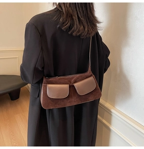Detail of vintage brown suede shoulder bag with two front pockets and zipper closure